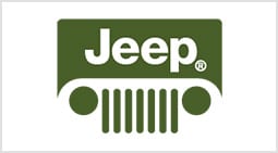 A jeep logo is shown on the side of a green car.